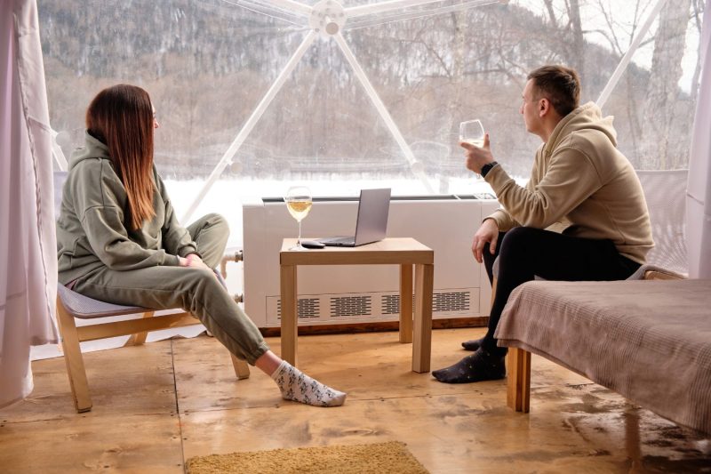 young couple enjoying a relaxing evening in their winter glamping spot